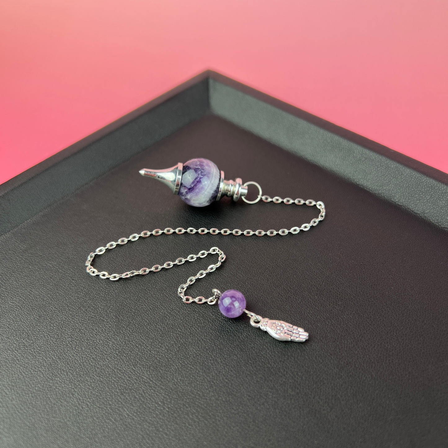 Amethyst and hand holding a lotus Sephoroton dowsing pendulum Baguette Magick