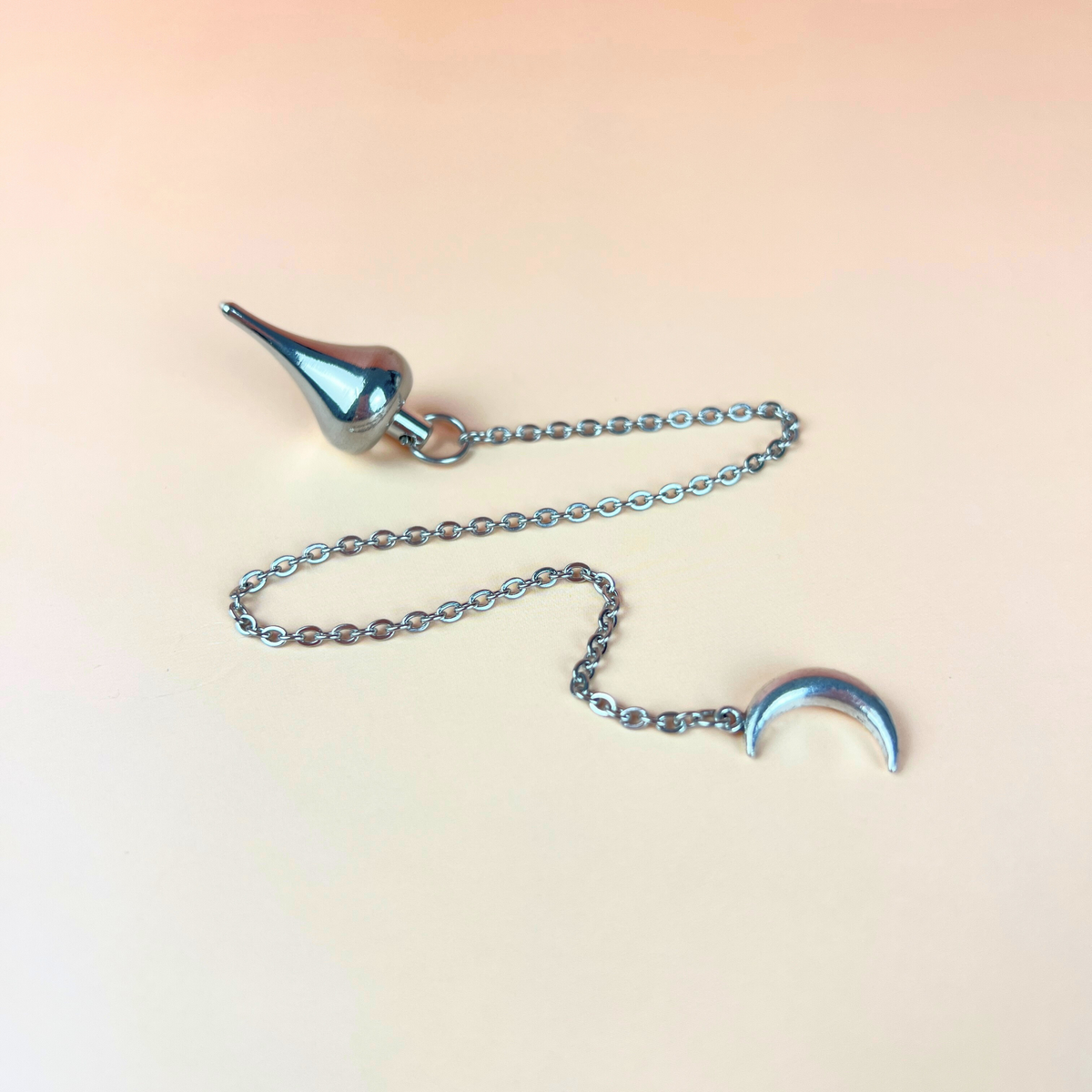 Luzi dowsing metal pendulum with a crescent Moon Baguette Magick