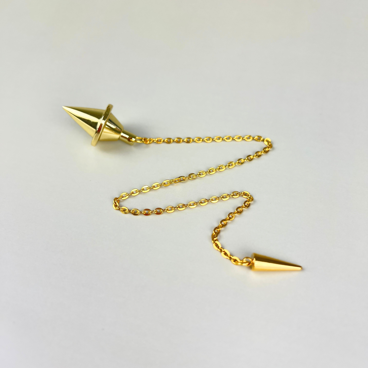 Golden double cone pendulum with a spike charm Baguette Magick
