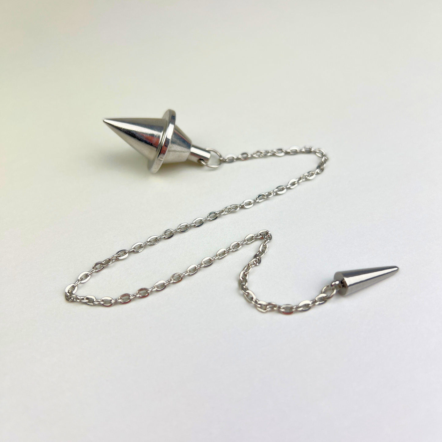 Silver-tone double cone pendulum with a spike charm Baguette Magick
