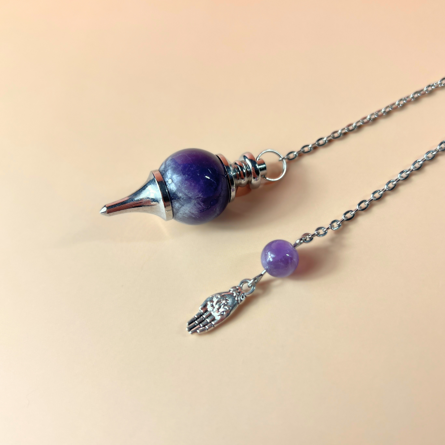 Amethyst and hand holding a lotus Sephoroton dowsing pendulum Baguette Magick