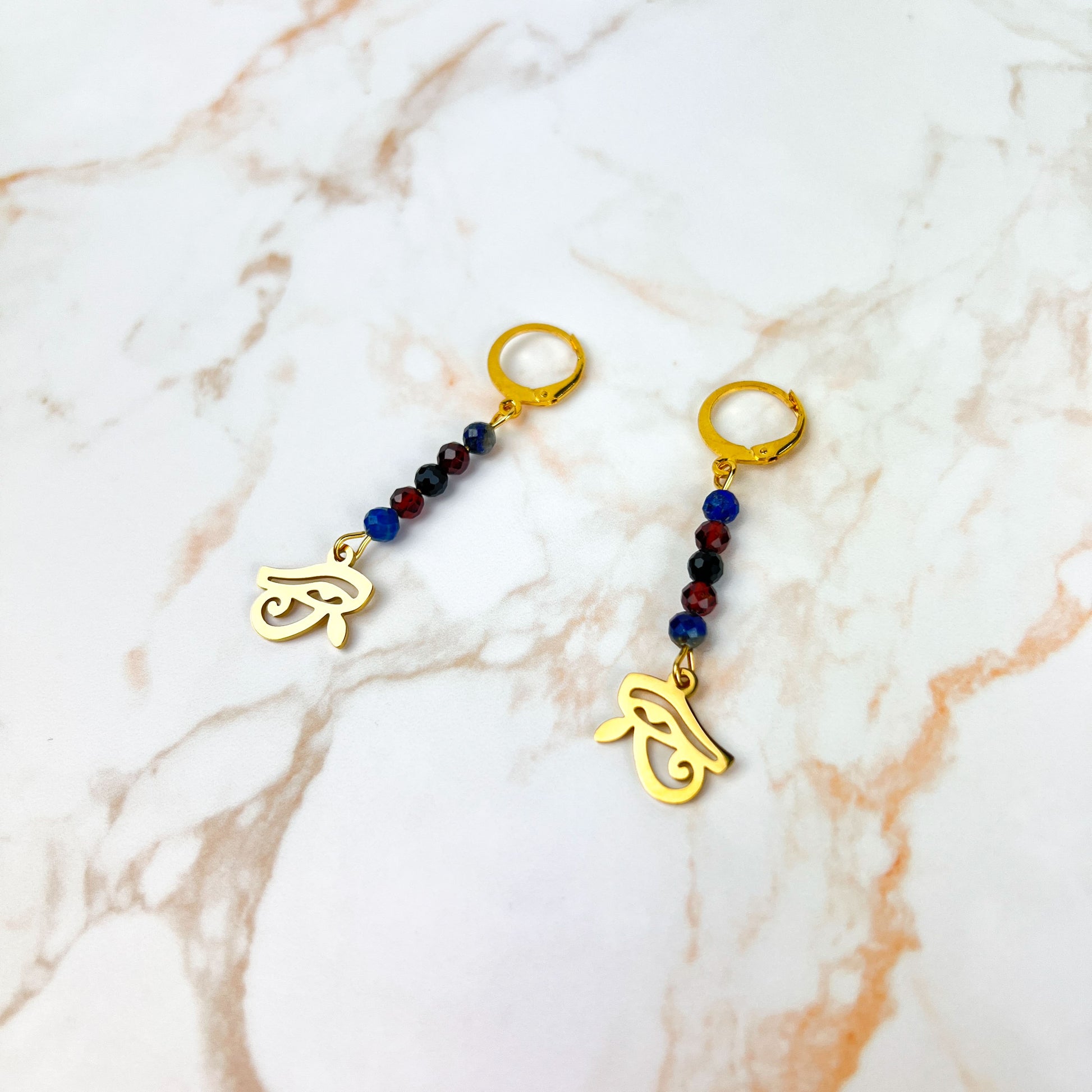 Eye of Horus earrings, golden stainless steel, lapis lazuli, garnet and onyx Baguette Magick