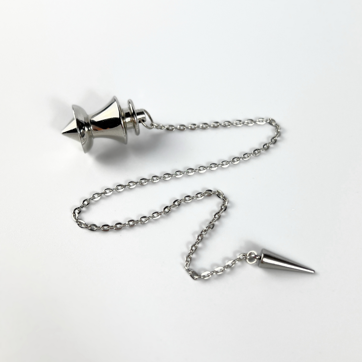 Point and dome dowsing metal pendulum with a spike charm