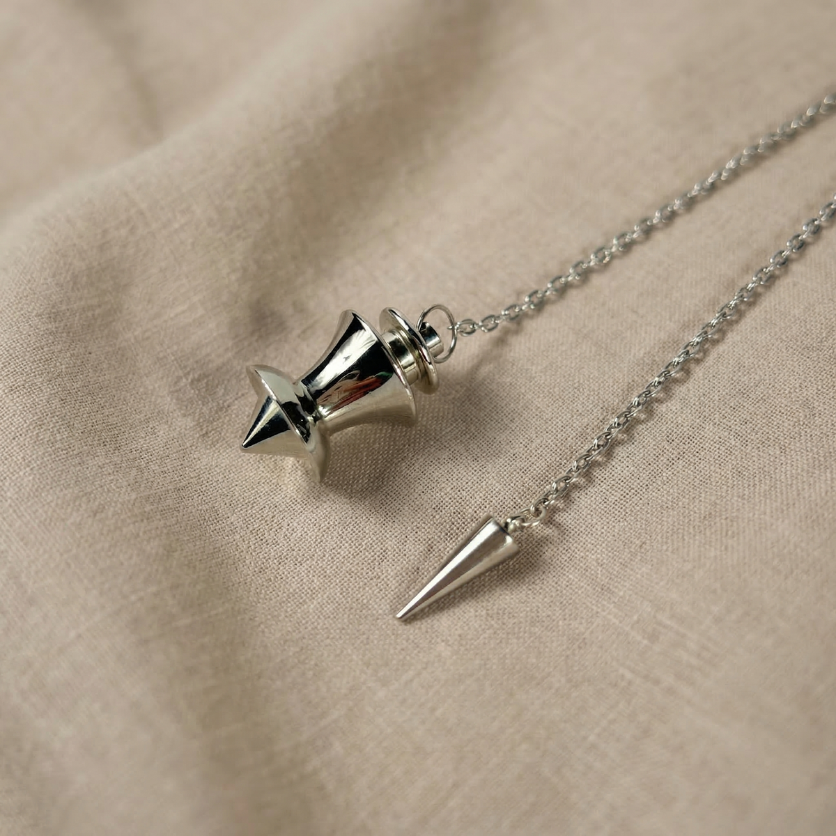 Point and dome dowsing metal pendulum with a spike charm