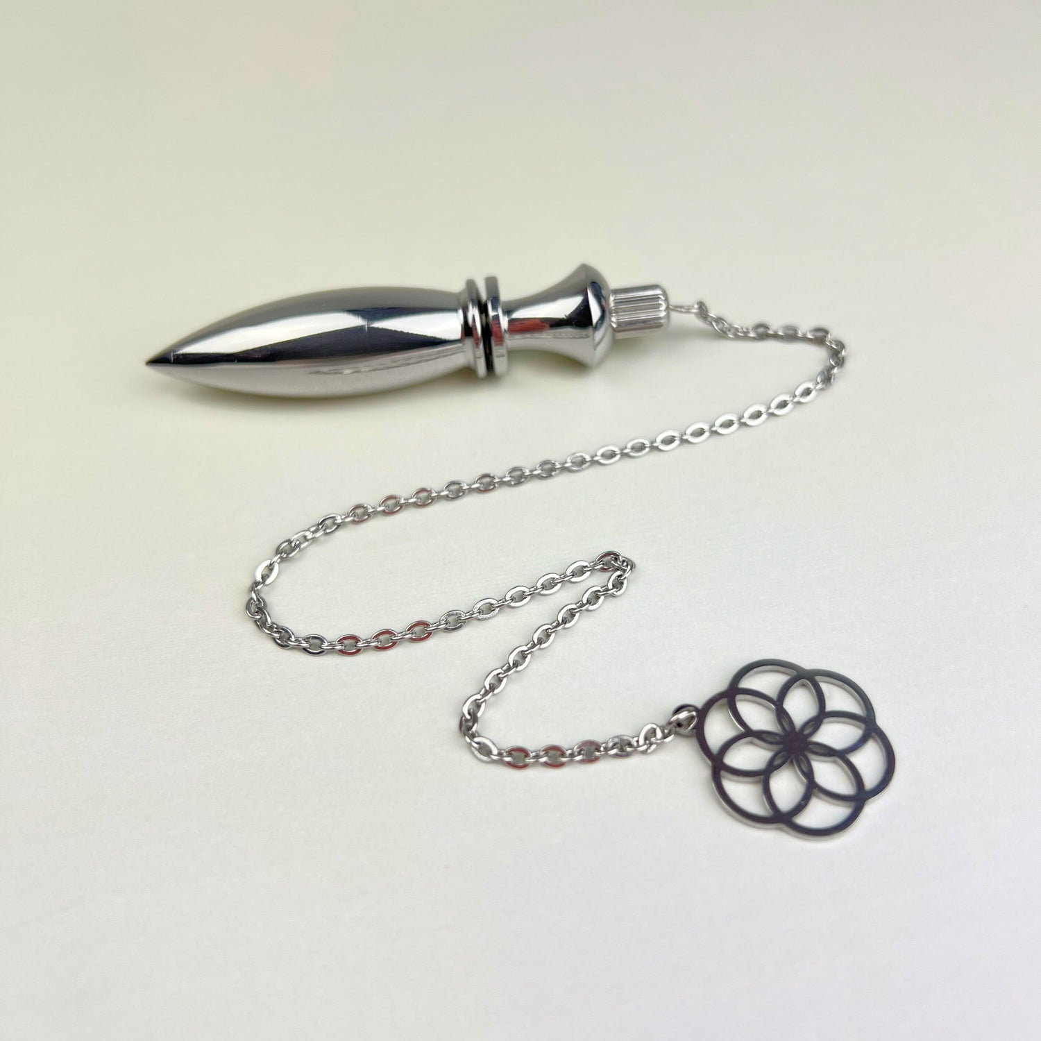 thot metal pendulum for divination and dowsing with a flower of life charm