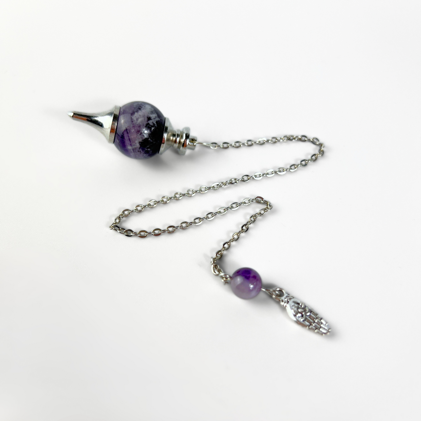 Amethyst and hand holding a lotus Sephoroton dowsing pendulum