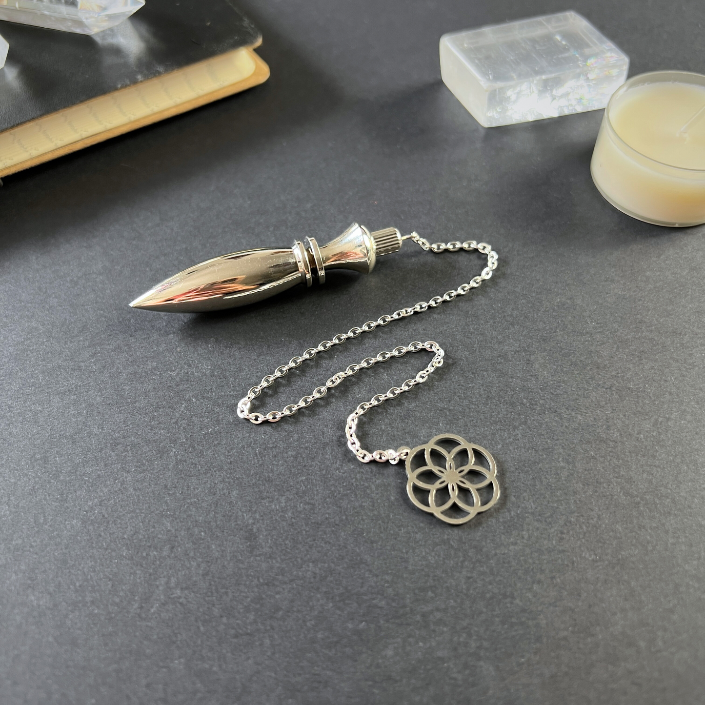 Metal Thot pendulum with a flower of life symbol