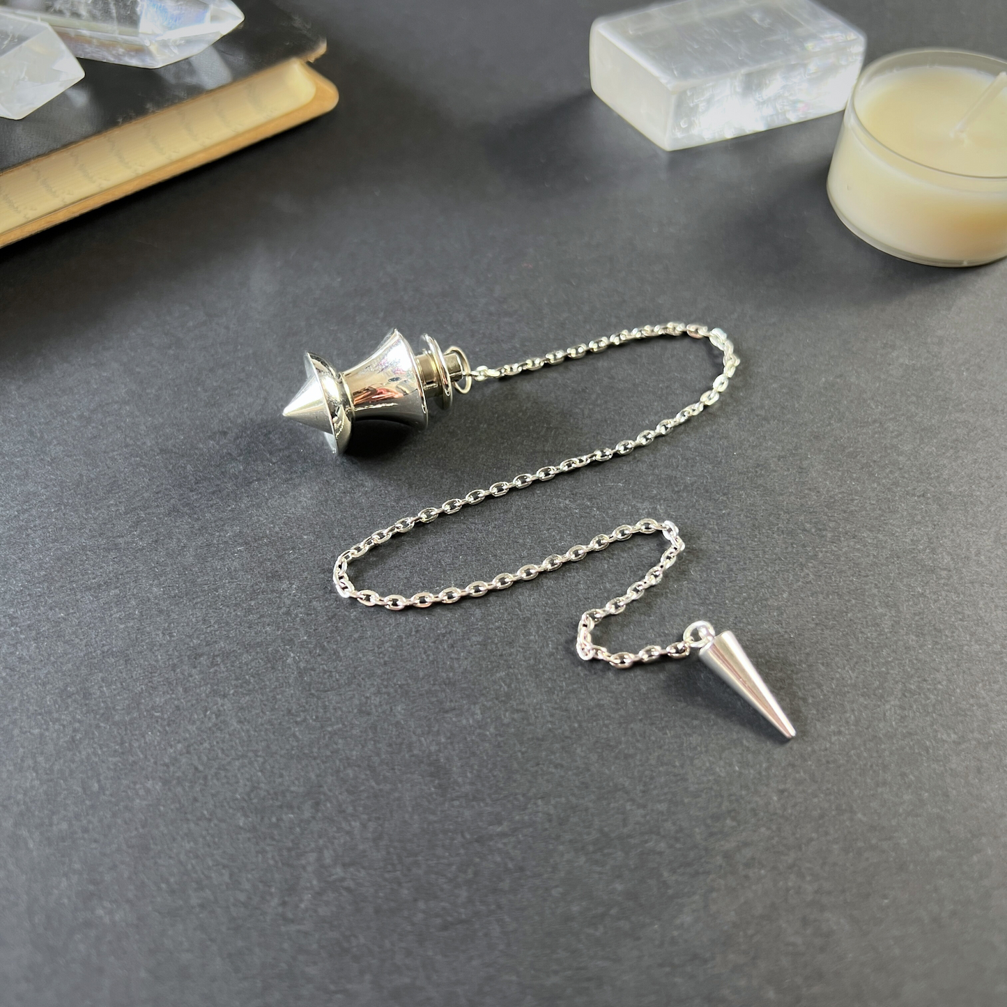 Point and dome dowsing metal pendulum with a spike charm