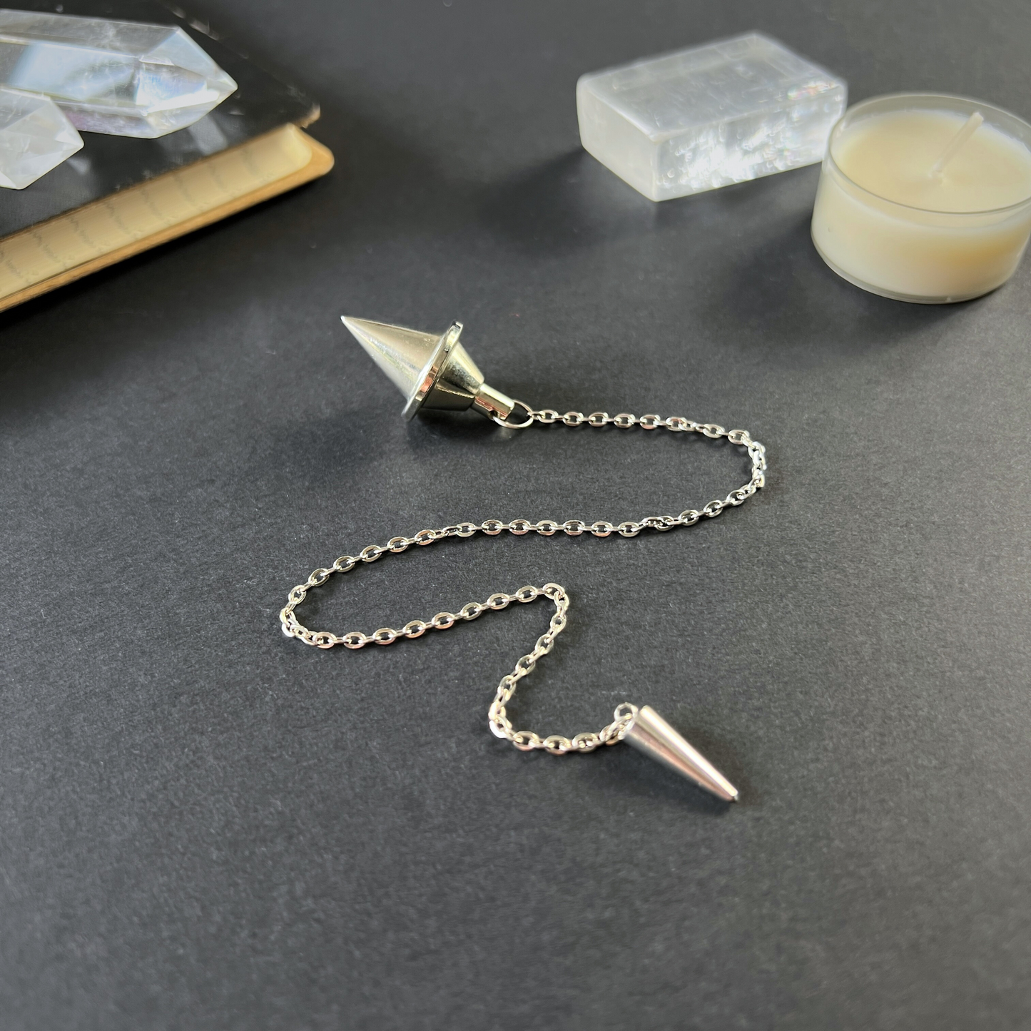 Silver-tone double cone pendulum with a spike charm