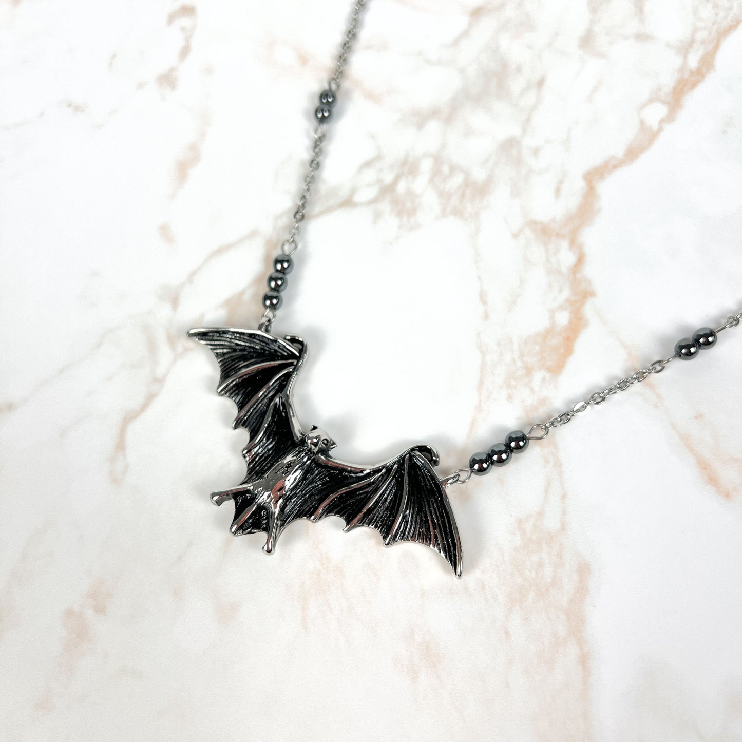 Stainless steel bat necklace with hematite beads Baguette Magick