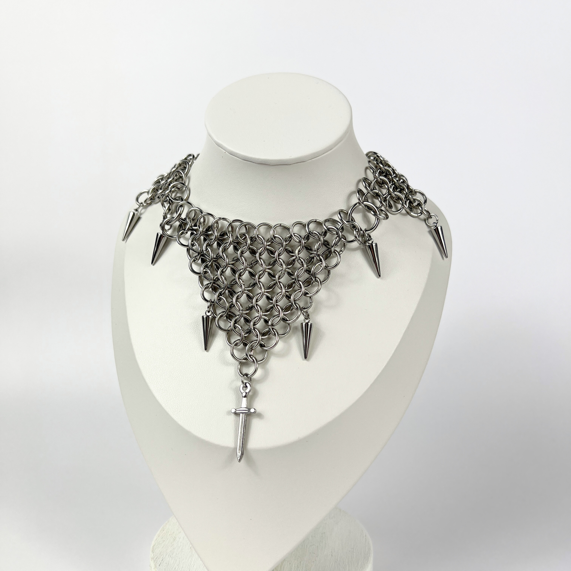 bold chainmail statement choker, with triangle parts, spikes, and dagger, silver tone stainless steel, corporate goth alt medieval fantasy style, necklace for women