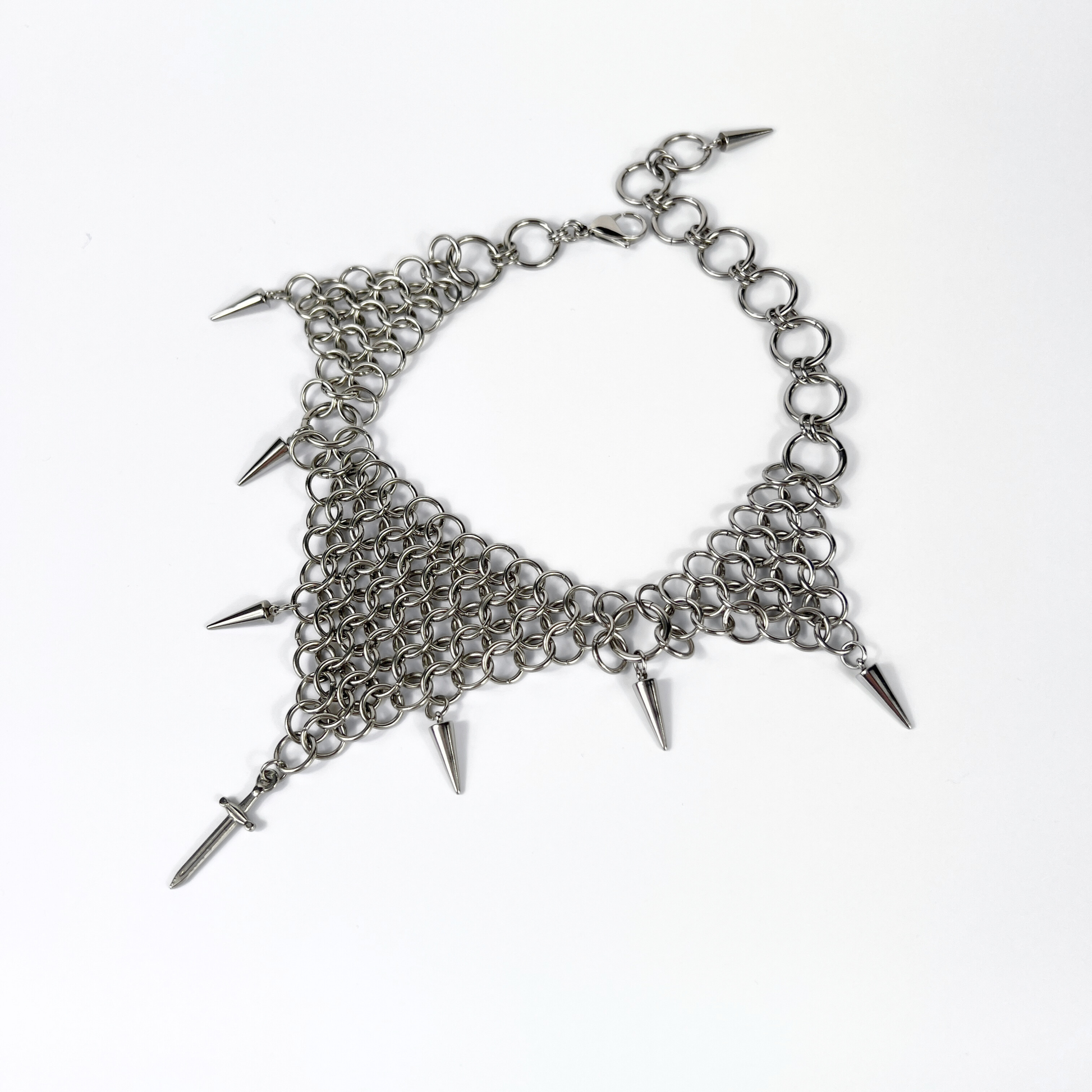 bold chainmail statement choker, with triangle parts, spikes, and dagger, silver tone stainless steel, corporate goth alt medieval fantasy style, necklace for women