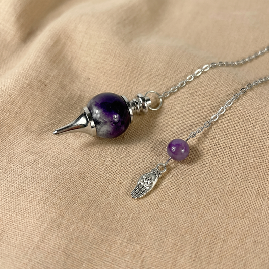 Améthyste et main tenant un pendule de radiesthésie Sephoroton lotus