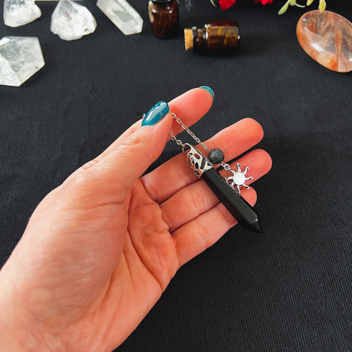 Onyx and lava rock dowsing pendulum with a sun charm The French Witch shop